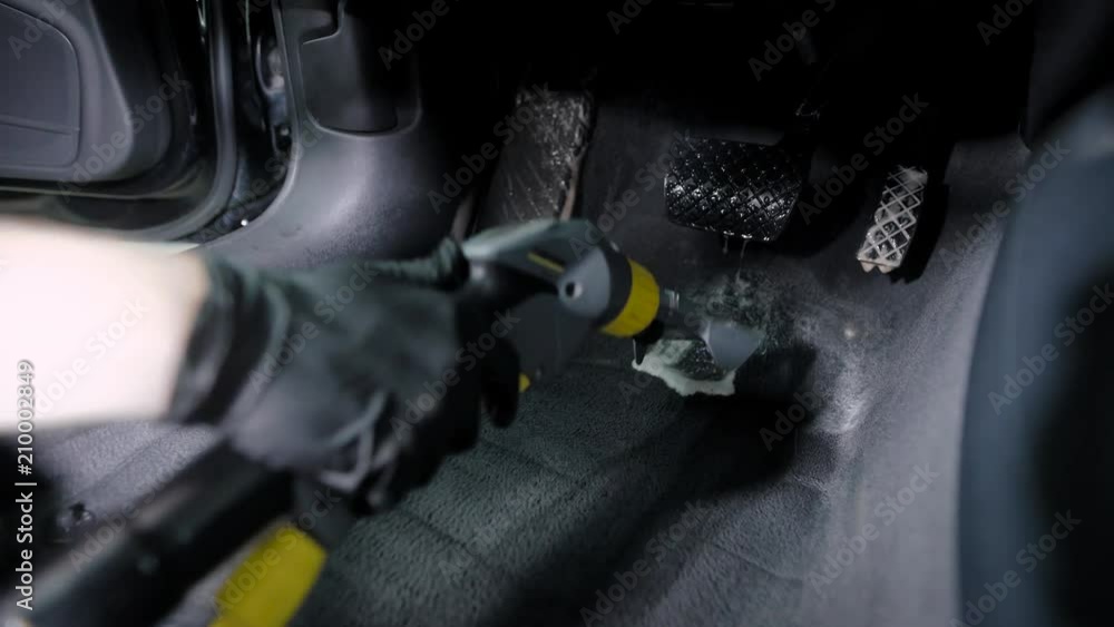 Close up shot of a master in gloves using washing vacuum cleaner for car's headliner. Close up shot of a master in gloves using washing vacuum cleaner for car's headliner.