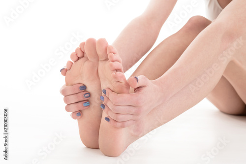 sensual female feet isolated over white background. Woman massaging legs © sasapanchenko