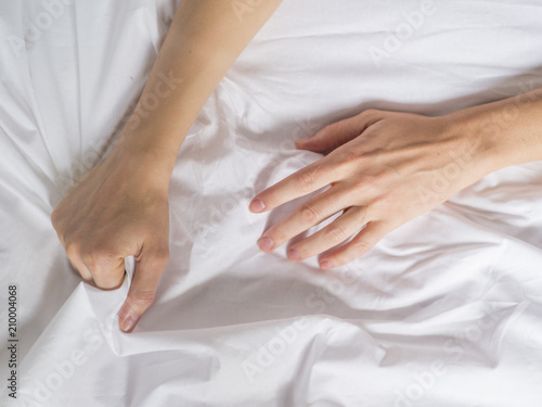 hands of women pulling white sheets in lust and orgasm
