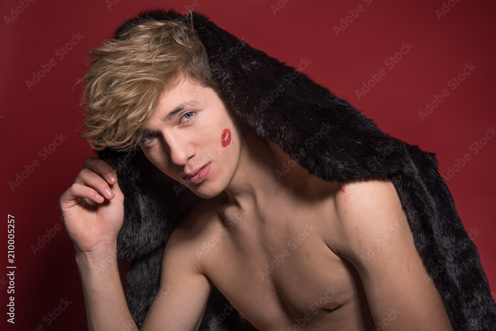 A man in black fur on red background. Sexy body A man in black fur on red background. Sexy body