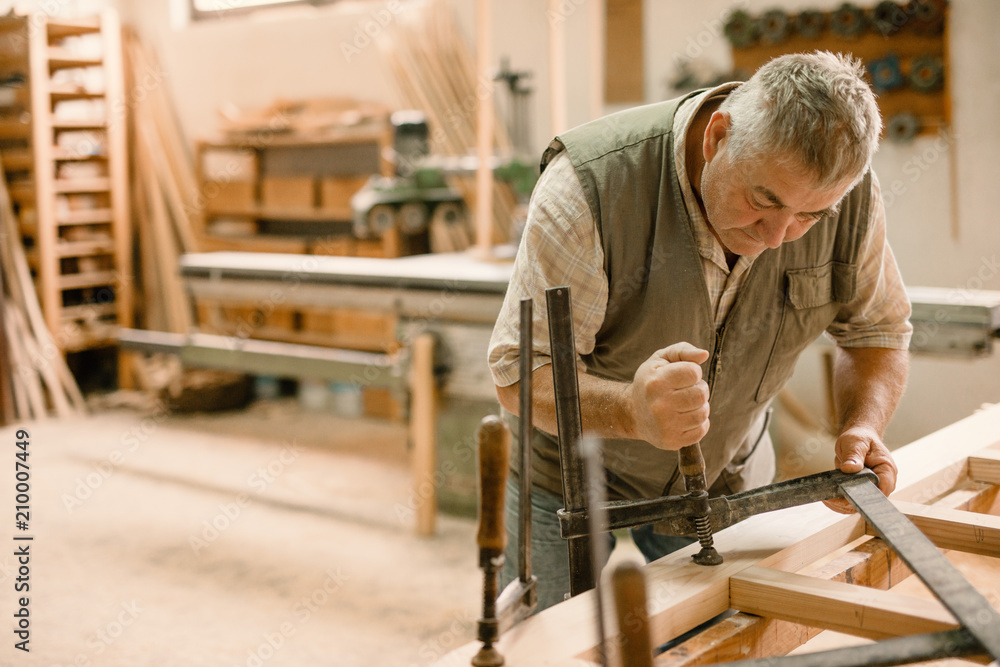 Carpenter working carefully looking at the plans - Image Carpenter working carefully looking at the plans - Image