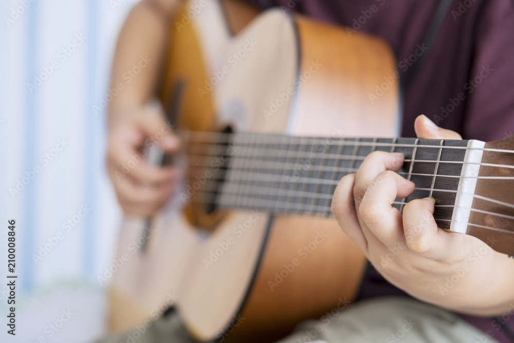 Unknown little boy is strumming acoustic guitar Unknown little boy is strumming acoustic guitar