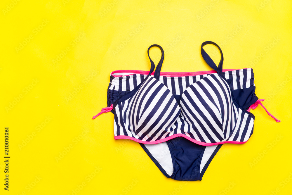 Fashion. Summer clothes, Accessories set- Trendy Swimsuit Bikini on the yellow background. Beach Outfit. Flat lay.Creative Art. Hot Vibes. Vacation and Relax Concept.Top view.
