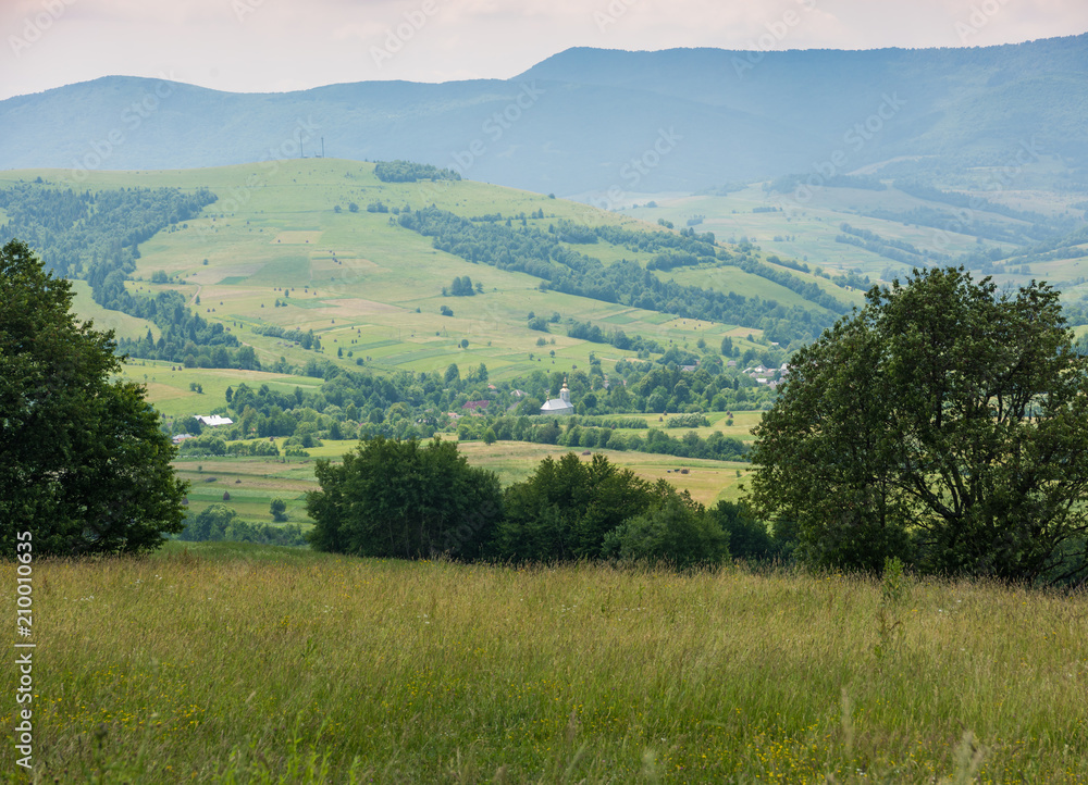 Beautiful view on small village in Ukraine. Small village in hills.Summer mountain landscape