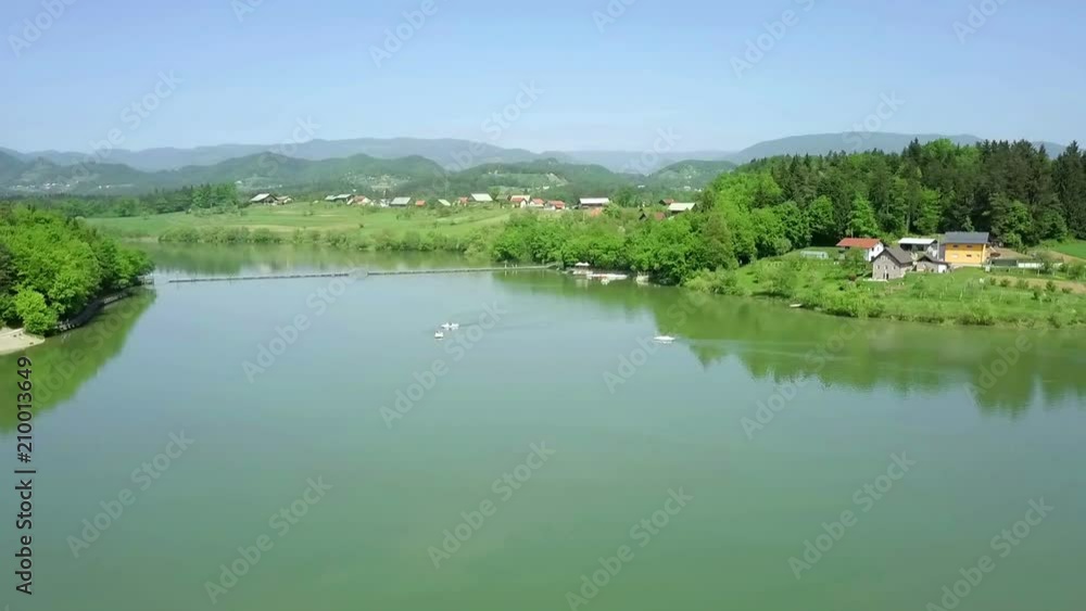 Aerial: Flying over green lake with few pedaling boats on it on sumer sunny day. Flying with drone and filming on beautiful sunny summer day. Aerial: Flying over green lake with few pedaling boats on it on sumer sunny day. Flying with drone and filming on beautiful sunny summer day.