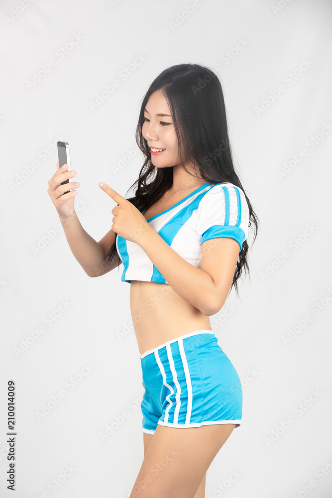 Cheerleader holds a smartphone, Cute, Beautiful stylish girls cheerleaders. Cheerleader holds a smartphone, Cute, Beautiful stylish girls cheerleaders.