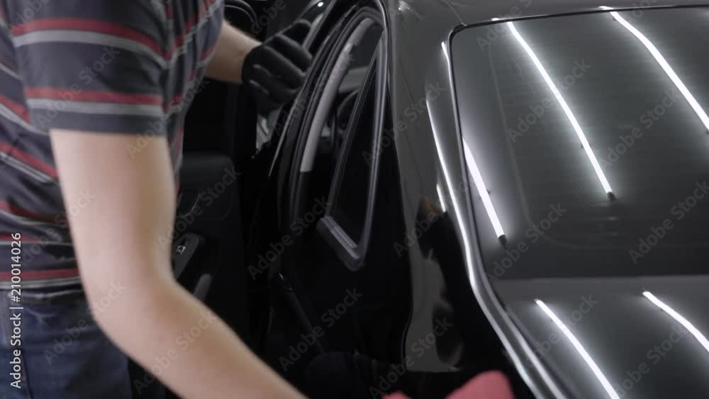 Man polishing car doors and roof clean after washing it. Man polishing car doors and roof clean after washing it.
