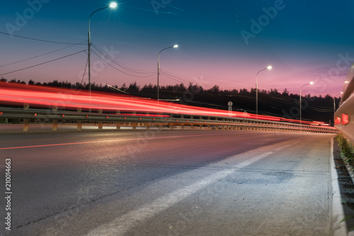 The car light trails on the road with metal safety barrier or rail