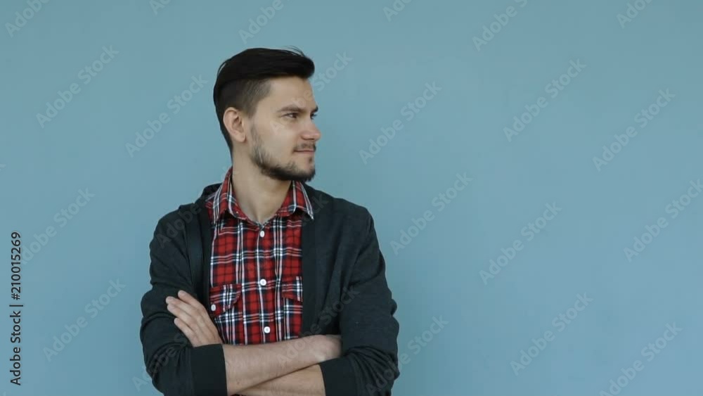 Slow motion portrait of happy young man looking stylish in the city. Man standing against the wall. Slow motion portrait of happy young man looking stylish in the city. Man standing against the wall.