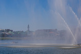 The motor boat rides under the spray of a huge fountain.Ancient Tatar village in the background.