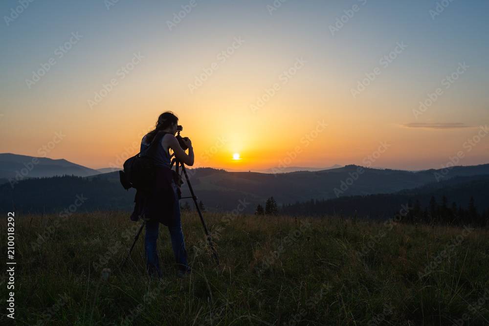Photographer shoots landscape at sunset