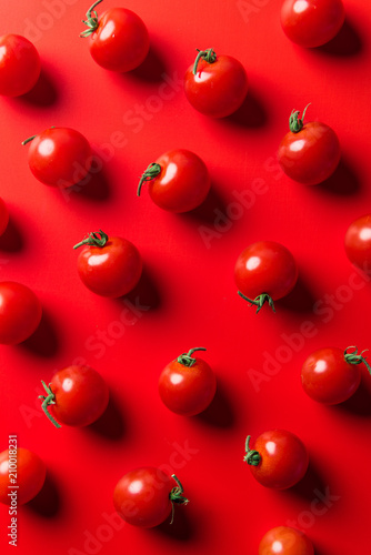 top view of pattern of cherry tomatoes on red surface