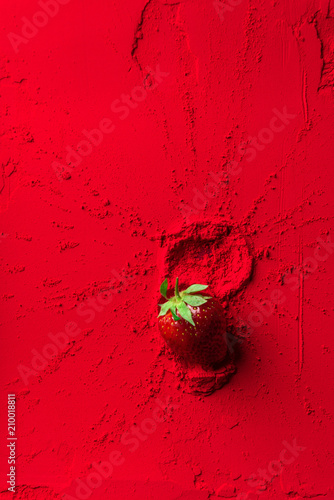 top view of red strawberry on red powder