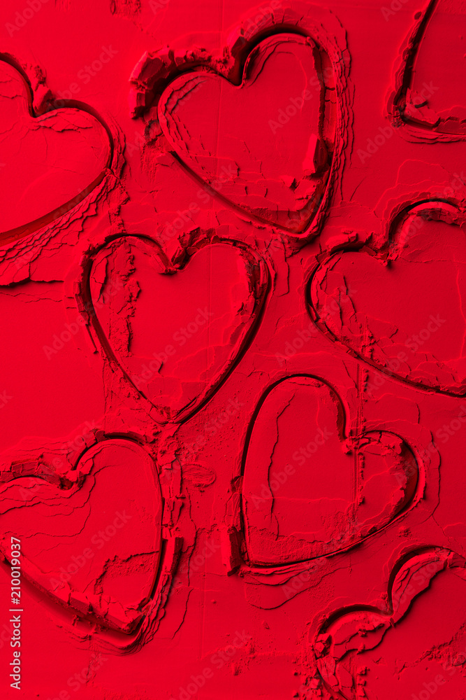 Obraz premium top view of shapes of cookie cutters in shape of hearts on red powder