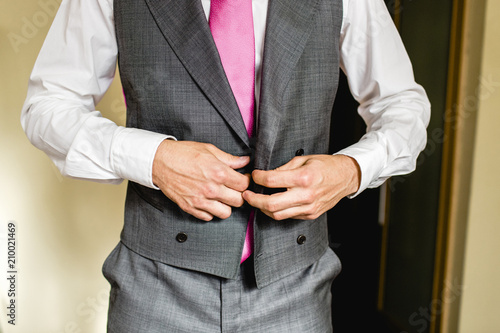 Groom dressing to go to his wedding