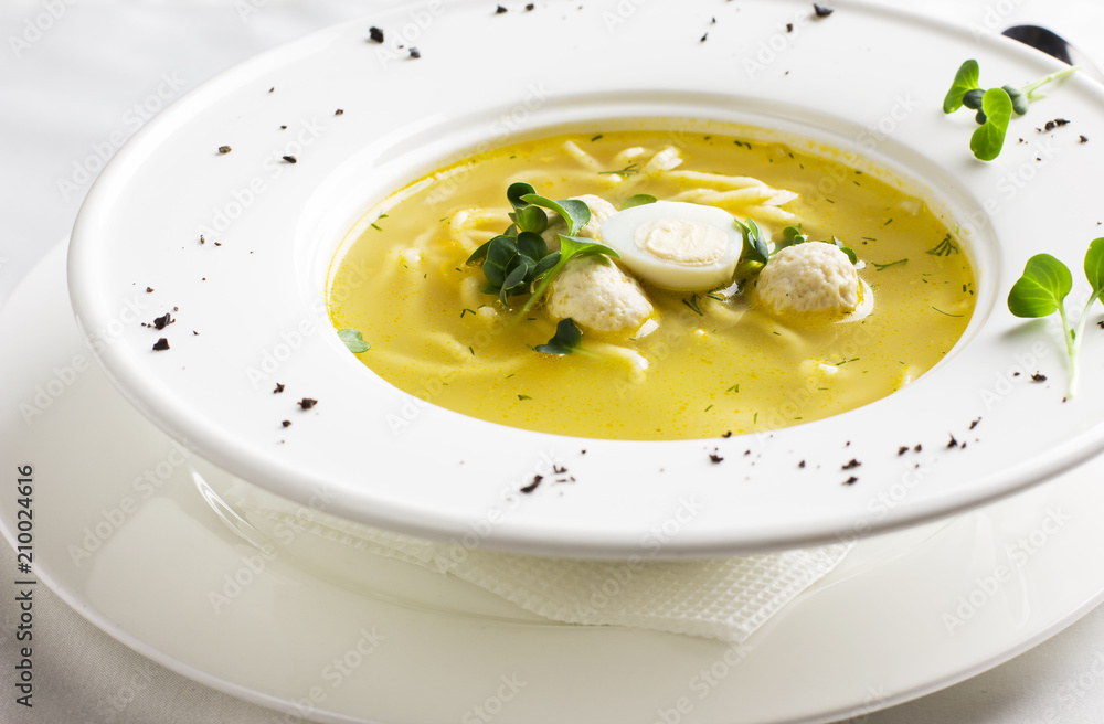 Chicken soup with meatballs, quail eggs and noodles in white plate Chicken soup with meatballs, quail eggs and noodles in white plate