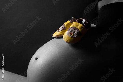 Babybauch mit gelben Schuhen photo