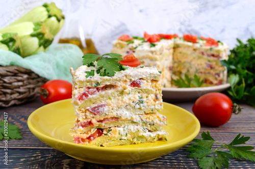 Foto A piece of delicious cake of zucchini, tomatoes and cheese on a wooden table