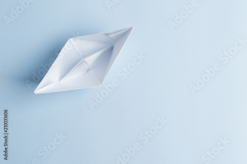Paper boat on light blue background