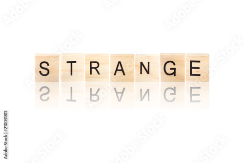 Strange word with reflection on wooden blocks on white isolated background.