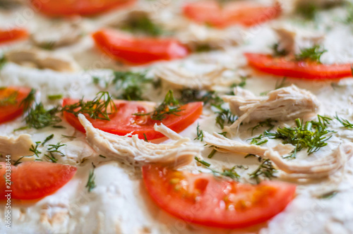 Pizza ingredients are closeup. Tomatoes, chicken, cheese, dill. Blurred background