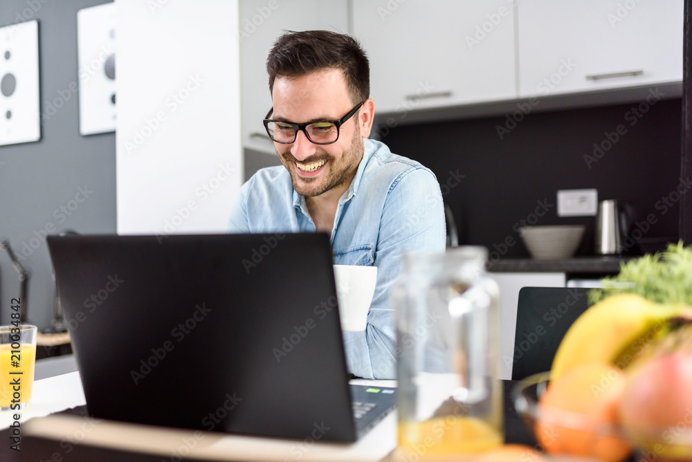 Businessman using laptop computer, working at his hotel room. Traveling for work. 