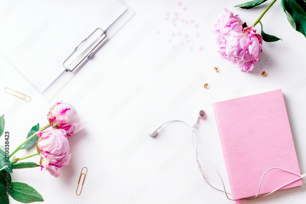 Feminine workspace with pink peons on white background with copy space