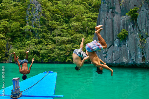Friends jumping and playing in the sea on a tropical beach holiday in El Nido, Palawan, Philippines