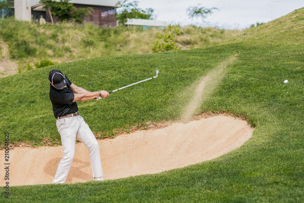 Man hitting golf ball out of a bunker