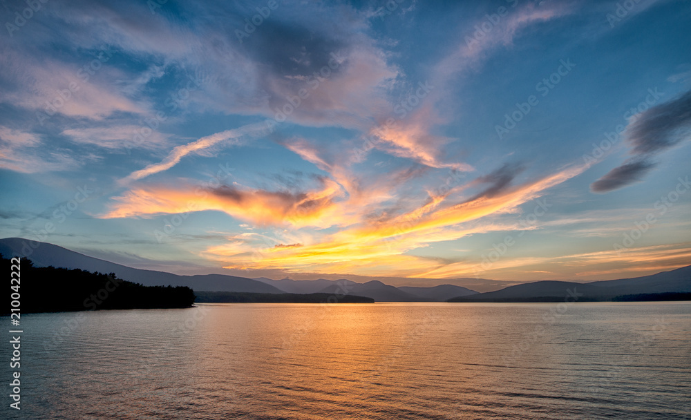 Dramatic Sunset with Blue Sky at the Ashokan Reservoir in Ulster County in New York. Golden light reflects on the Mountains and calm reservoir surface.