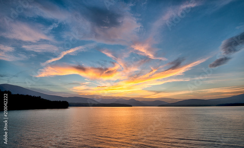 Dramatic Sunset with Blue Sky at the Ashokan Reservoir in Ulster County in New York. Golden light reflects on the Mountains and calm reservoir surface. photo