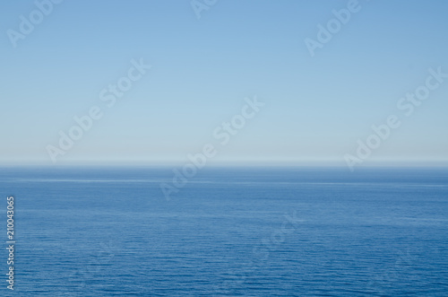 Simple background of blue Mediterranean sea against clear blue sky