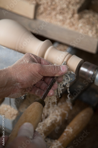 Carpenter turning hard wood on a lathe  hands close up