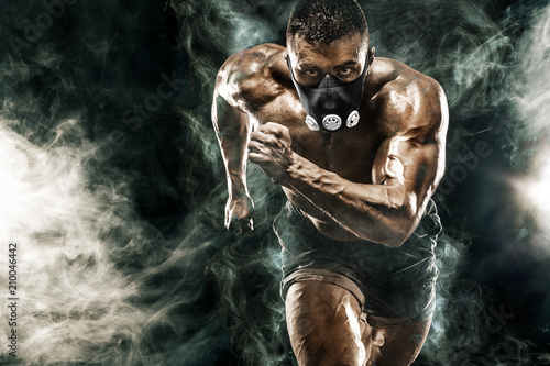 Fototapeta Naklejka Na Ścianę i Meble -  Strong athletic man sprinter in training mask, running, fitness and sport motivation. Runner concept with copy space. Dynamic movement.