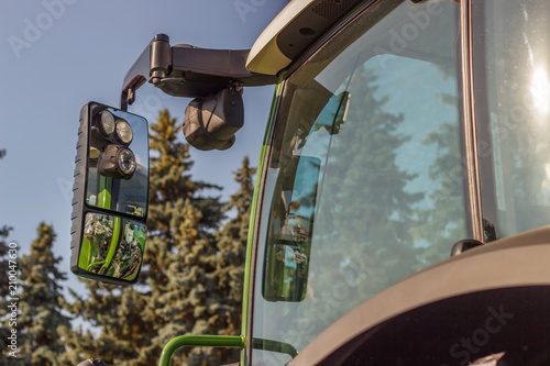 A cab of a modern tractor against the blue sky. Mechanization of agriculture.