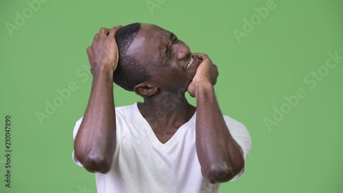Young African man having neck pain and cracking neck