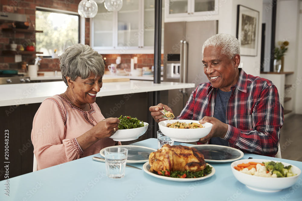 Senior Couple Enjoying Meal Around Table At Home Senior Couple Enjoying Meal Around Table At Home