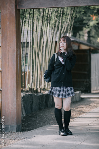 Portrait Asian japanese school girl costume looking in japanese garden © Oran Tantapakul