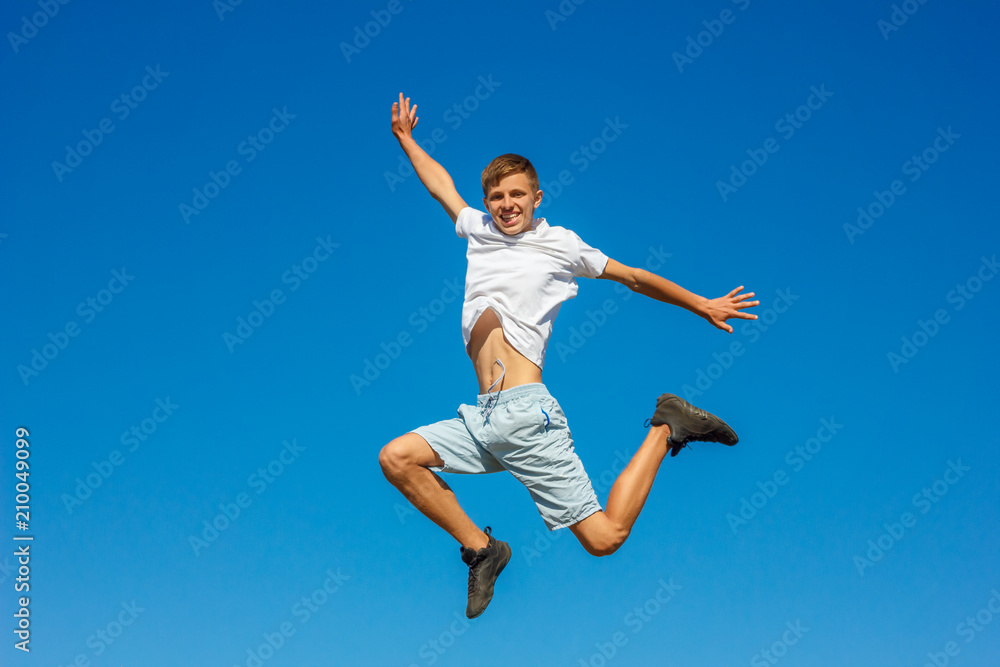 happy boy jumping in the blue sky , concept of happiness happy boy jumping in the blue sky , concept of happiness