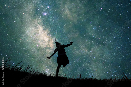 Silhouette of student girl running in glass fields and full of stars in the sky at night. Concept Explorer, discovery, mystery story, Children's dream photo