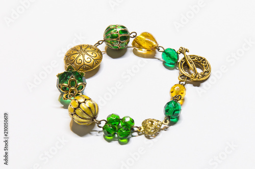 A bracelet with gold, amber and emerald elements. Jewelry.
