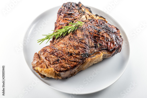 White round plate with Whole grilled T-bone steak and rosemary photo