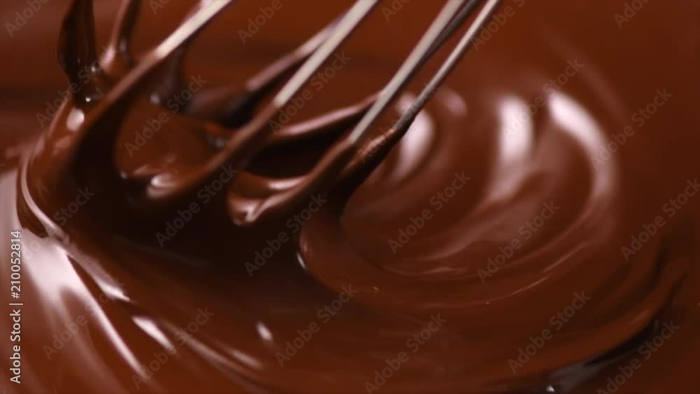 Chocolate. Mixing melted dark chocolate with a whisk. Closeup of liquid hot chocolate swirl. Confectionery. Slow motion 4K UHD video 3840X2160