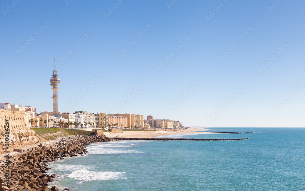 Cadiz waterfront in Spain and the view along the beach of Santa Maria del Mar.