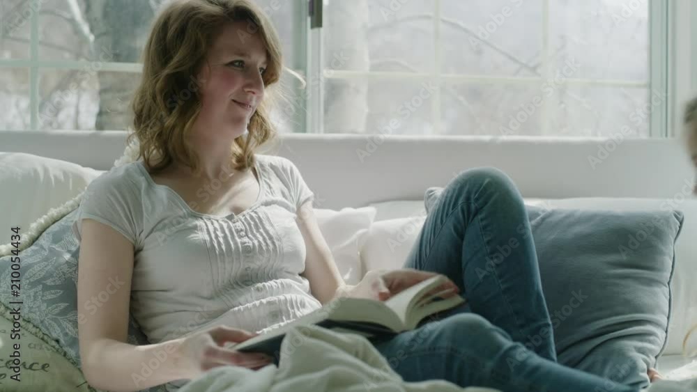 Mother reading book in bed then hugging and comforting daughter / Pleasant Grove, Utah, United States Mother reading book in bed then hugging and comforting daughter / Pleasant Grove, Utah, United States