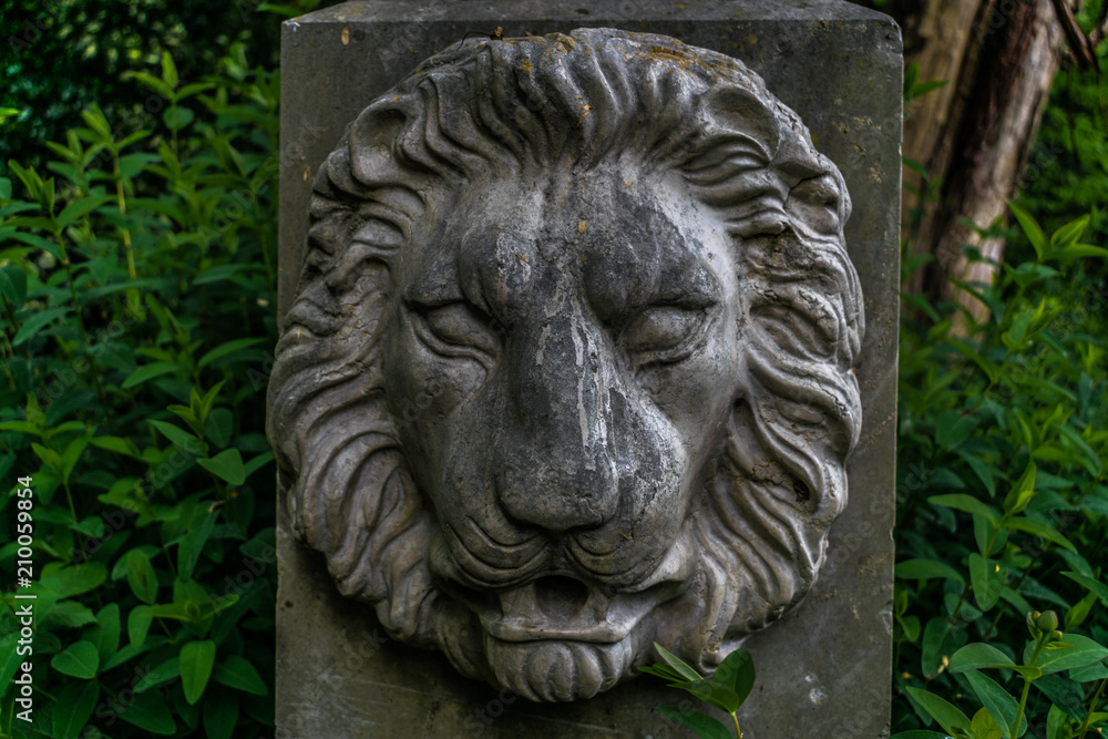Pietra miliare con effige di leone in un giardino pubblico italiano