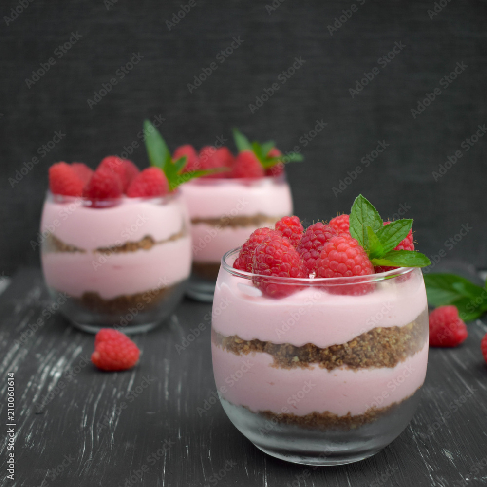 Sweet raspberry mousse in glass bowl on dark background Sweet raspberry mousse in glass bowl on dark background