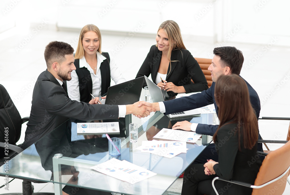 handshake of business partners sitting at your Desk handshake of business partners sitting at your Desk