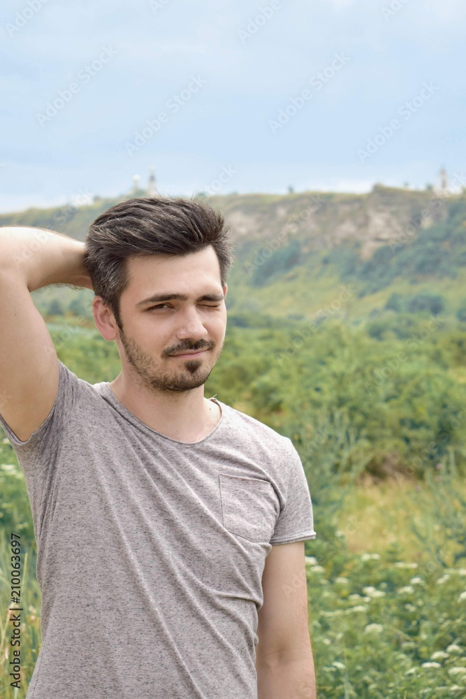 Portrait of a young man on a background of nature, spring, summer.