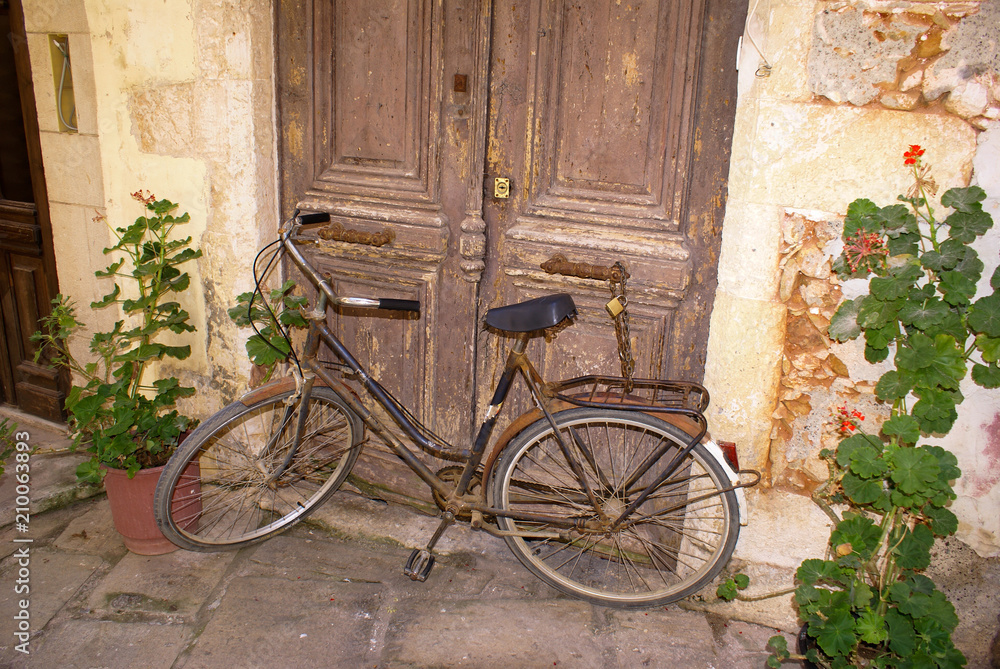 Vintage Bicycle Leaning against old door in Chania city, Greece